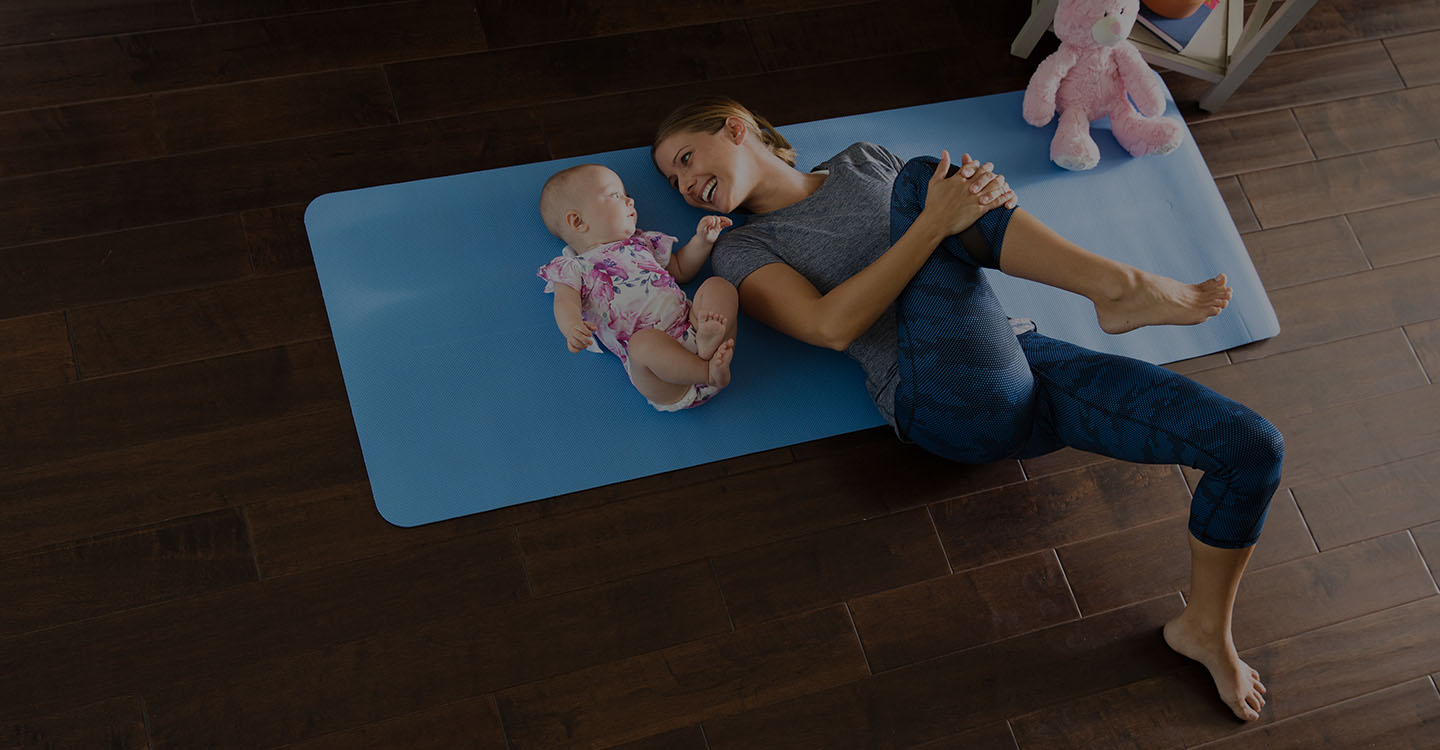 Mother and baby stretching on a yoga mat